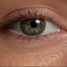 Close-up of a person's eye with detailed iris and eyelashes.