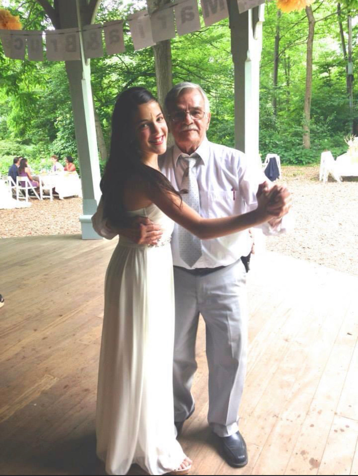 Paige and her Grandfather, Popou, slow dancing at her aunt's wedding. Photo credit to Lauren DeAngelo.